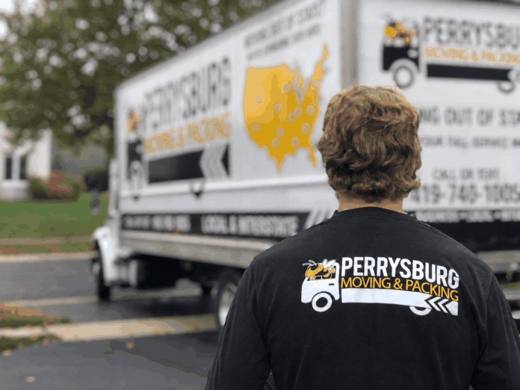 Perrysburg Moving team member in a branded shirt beside a moving truck