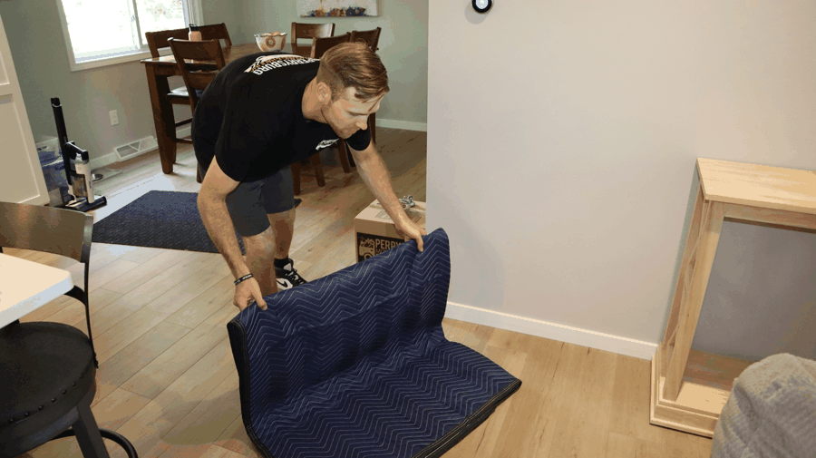 Perrysburg Moving employee carefully padding a chair inside a customer's home